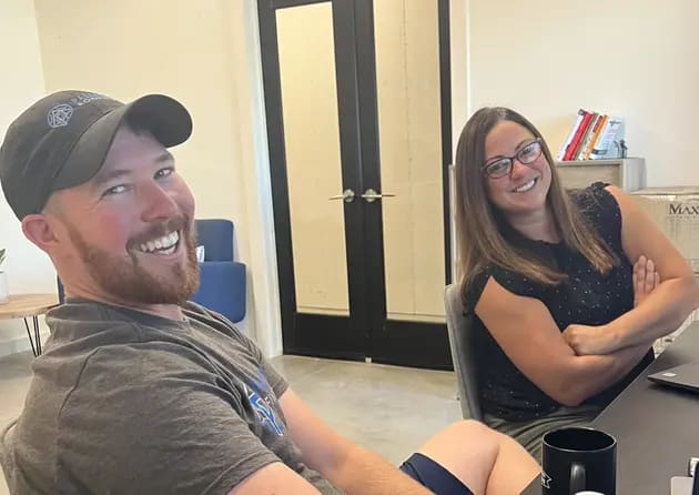 two palladium roofing team members smiling in their office