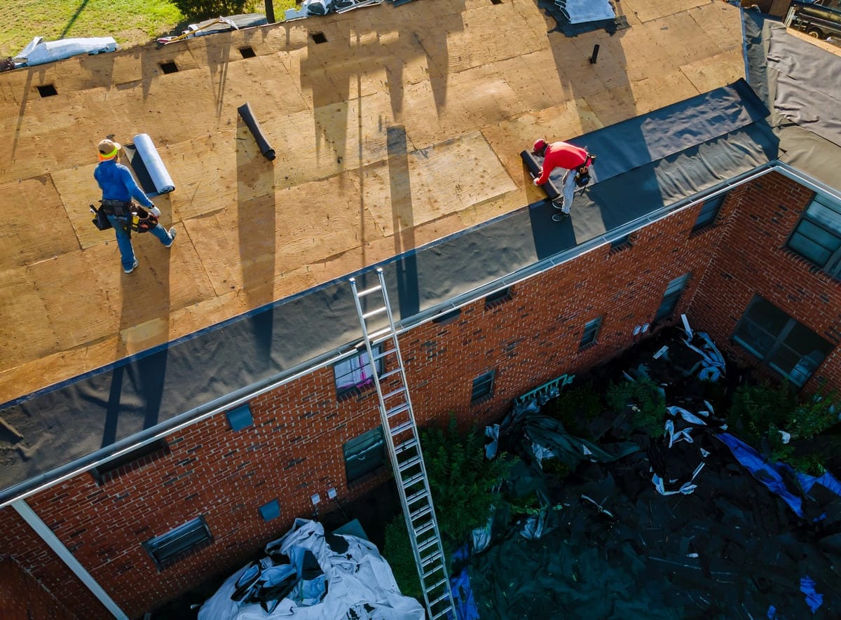 workers on the damaged house roof
