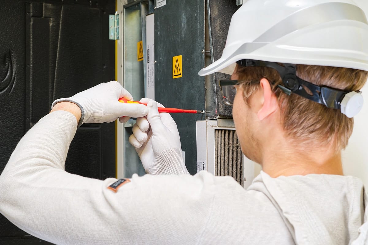 forced air heating-technician performing maintenance of furnace