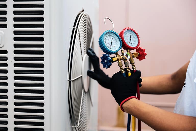 hvac refrigerant-tech using tool to measure refrigerant on hvac system
