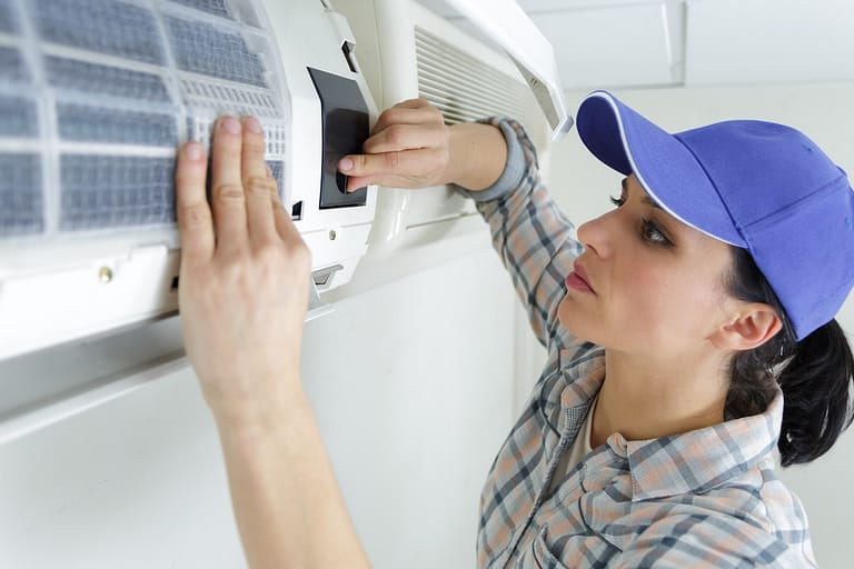 female technician working on air conditioning unit