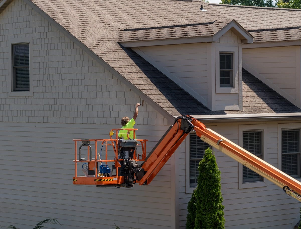 painting siding with equipment