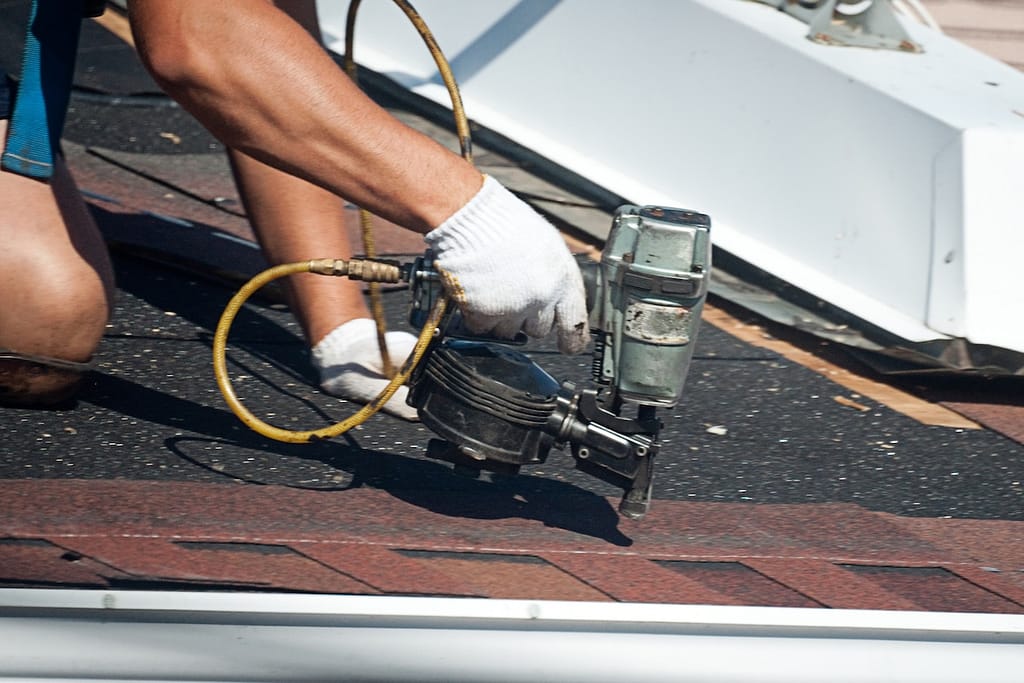 Roofer installing roof shingles