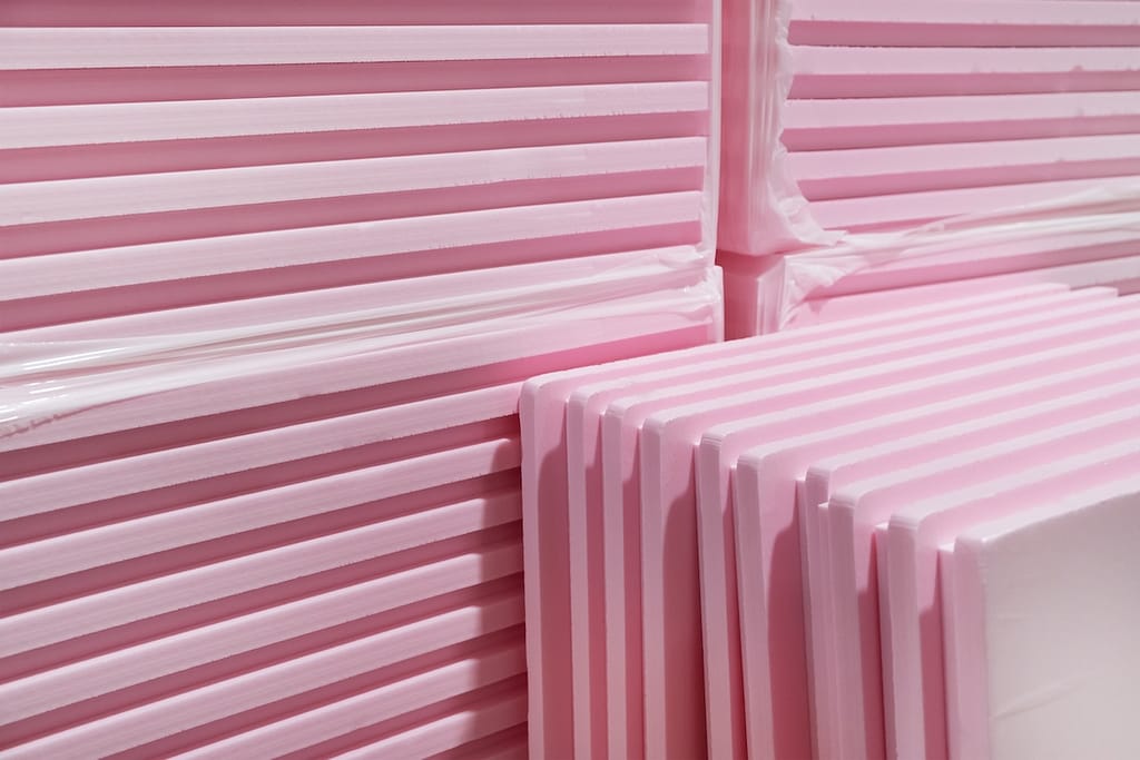 Pink Extruded Polystyrene XPS foam thermal insulation boards stacked in construction site. High Density, water absorption. Eco energy saving technology
