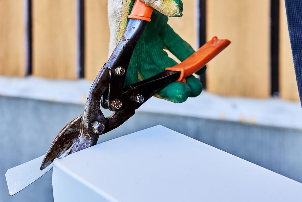 using tin snips to cut metal roofing