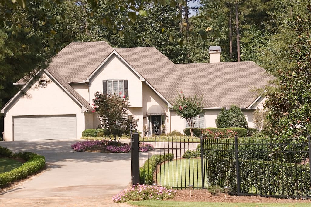 A nice stucco house behind an iron fence