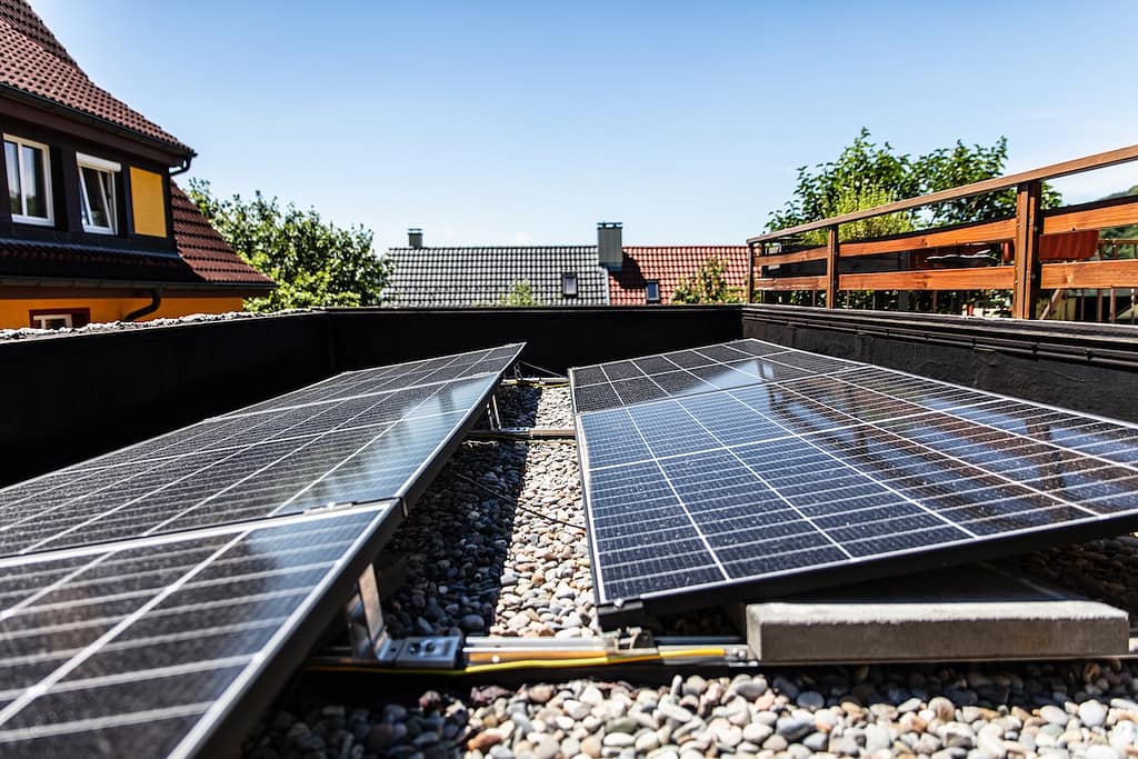 Solar modules or pv panels on a flat roof with pebbles and a special substructure