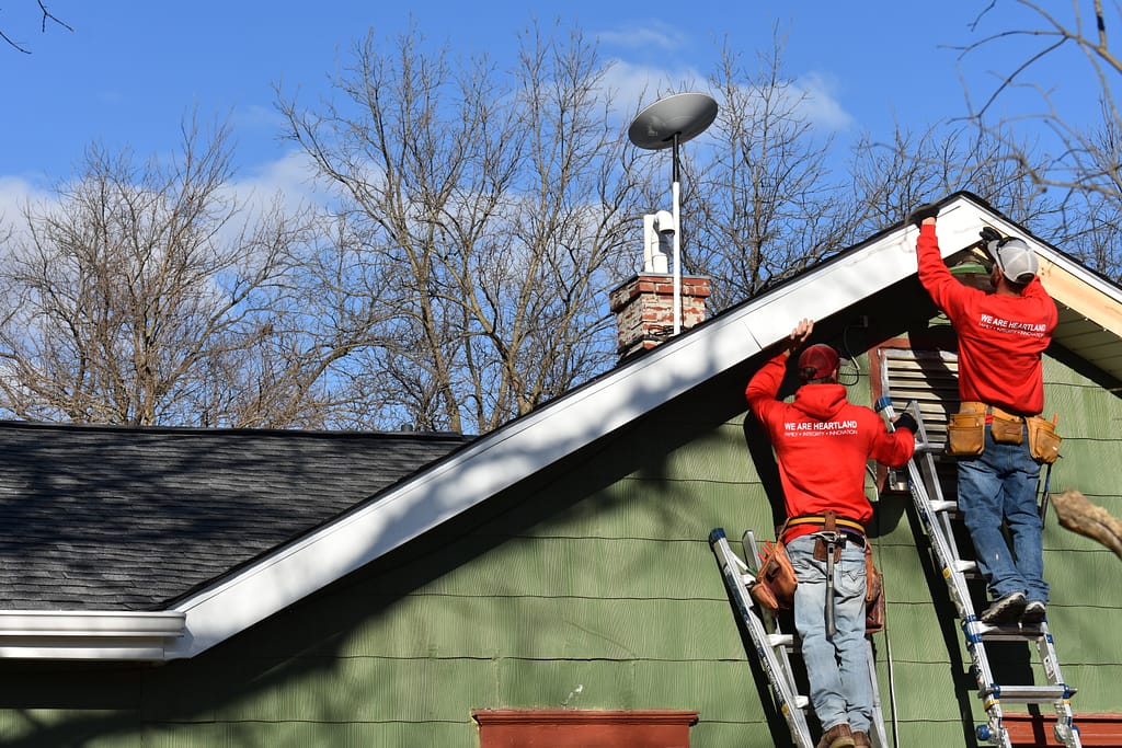 commercial roof replacement workers repairing roof