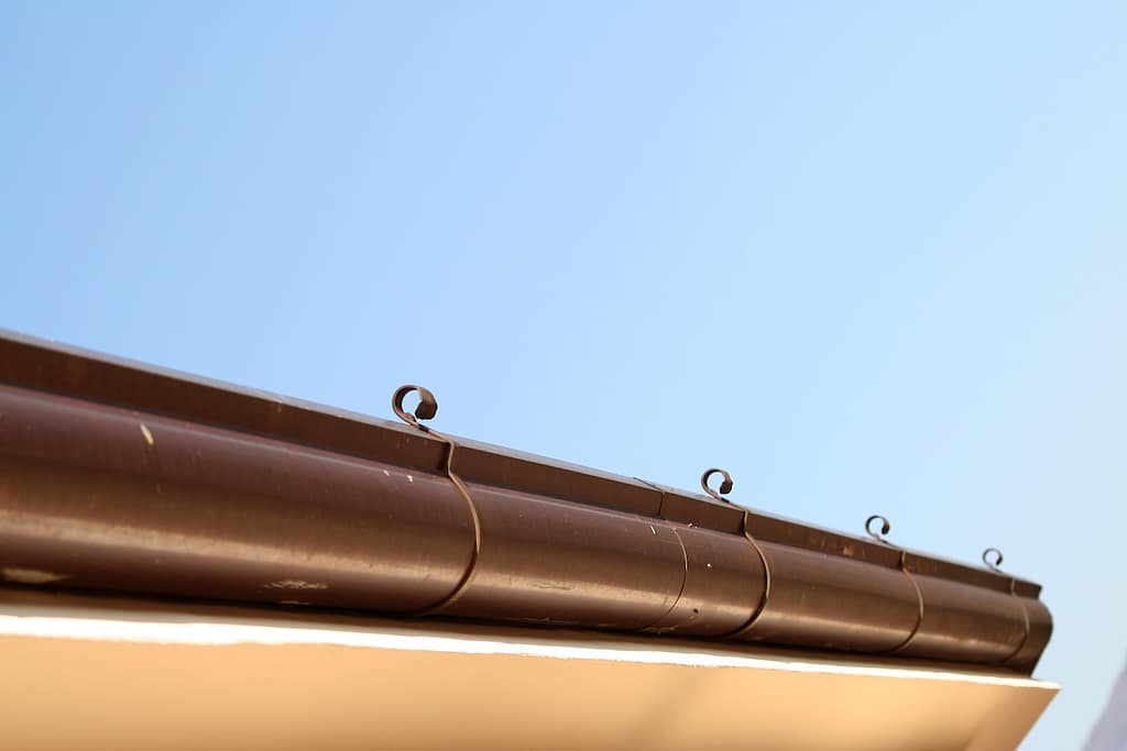 brown copper gutter under a cloudy sky