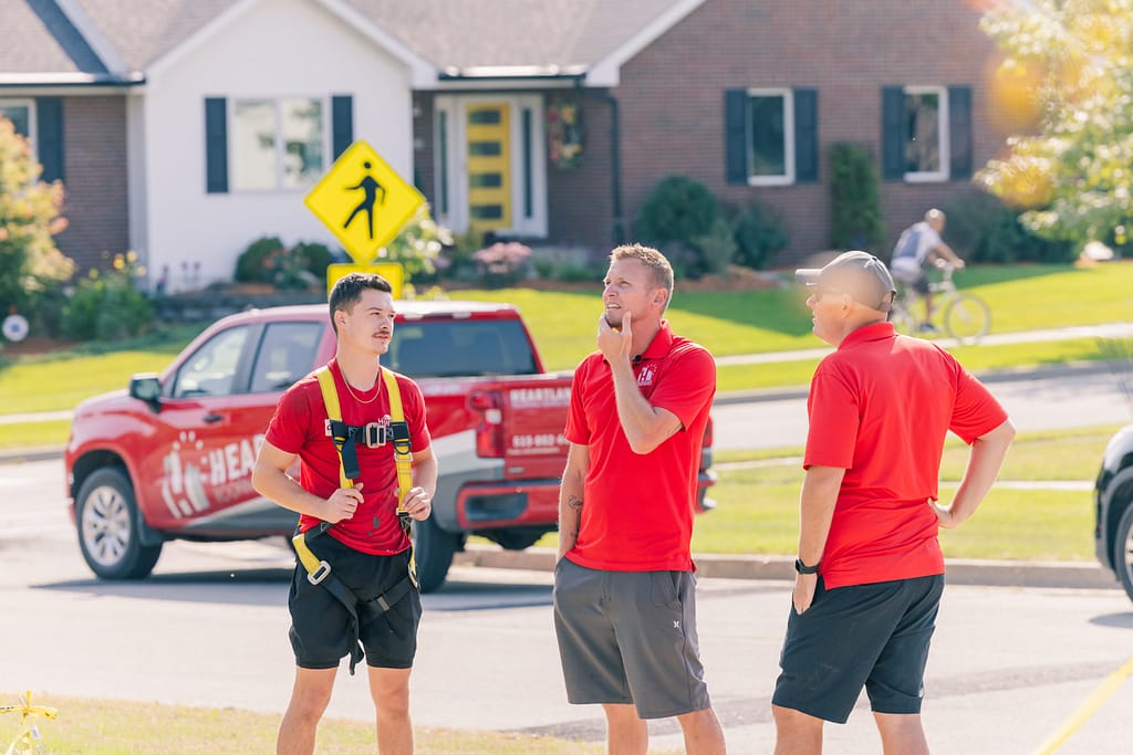 how to get insurance to pay for roof replacement Heartland workers standing outside of the street