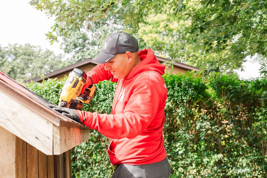hail damage roof repair worker using screwdriver