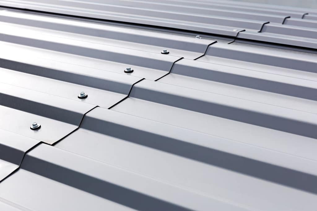 metal roof panels workers installing corrugated metallic roof light grey corrugated roof close up