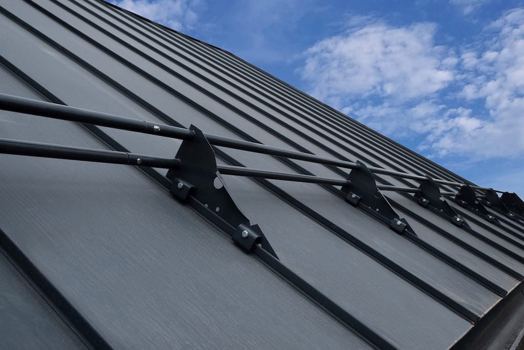 Snow guards for standing seam metal roofs