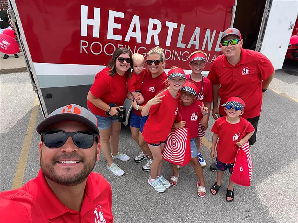 Heartland employees taking a selfie in front of a branded trailer