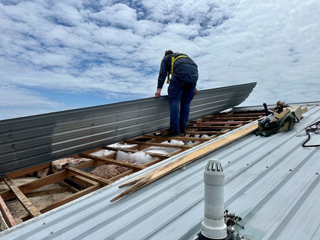 metal roof panels workers installing corrugated metallic roof