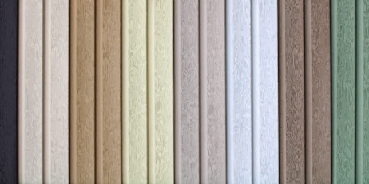 multicolored strips of vinyl siding samples for facing the walls of buildings as a background.