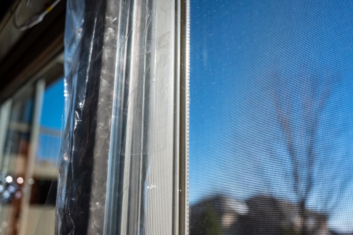 DIY Winterizing a glass door by applying thermal plastic with tape and heat shrinking it