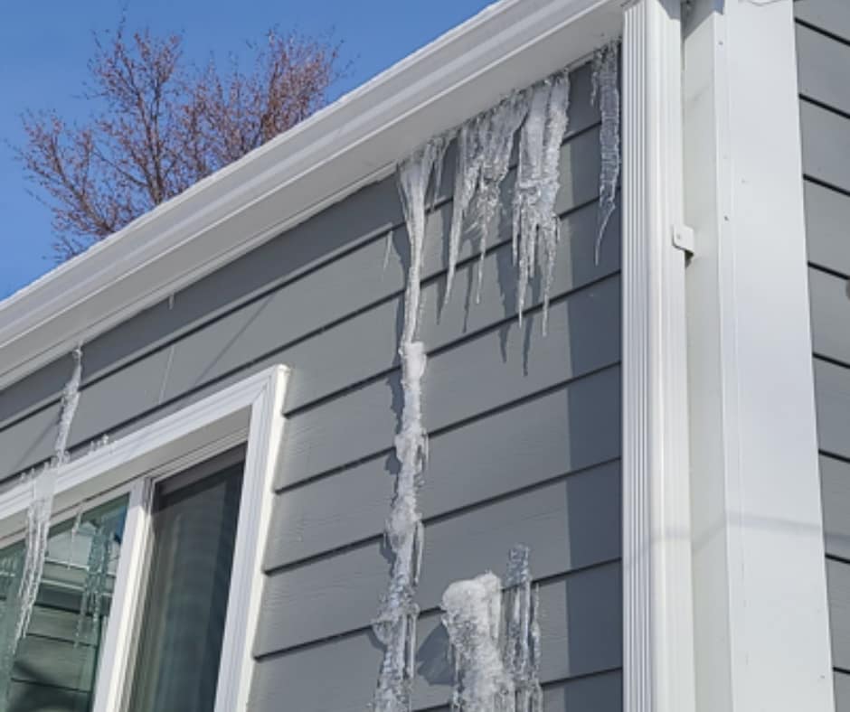 Ice buildup along the roofline and gutters of an Iowa home during winter.