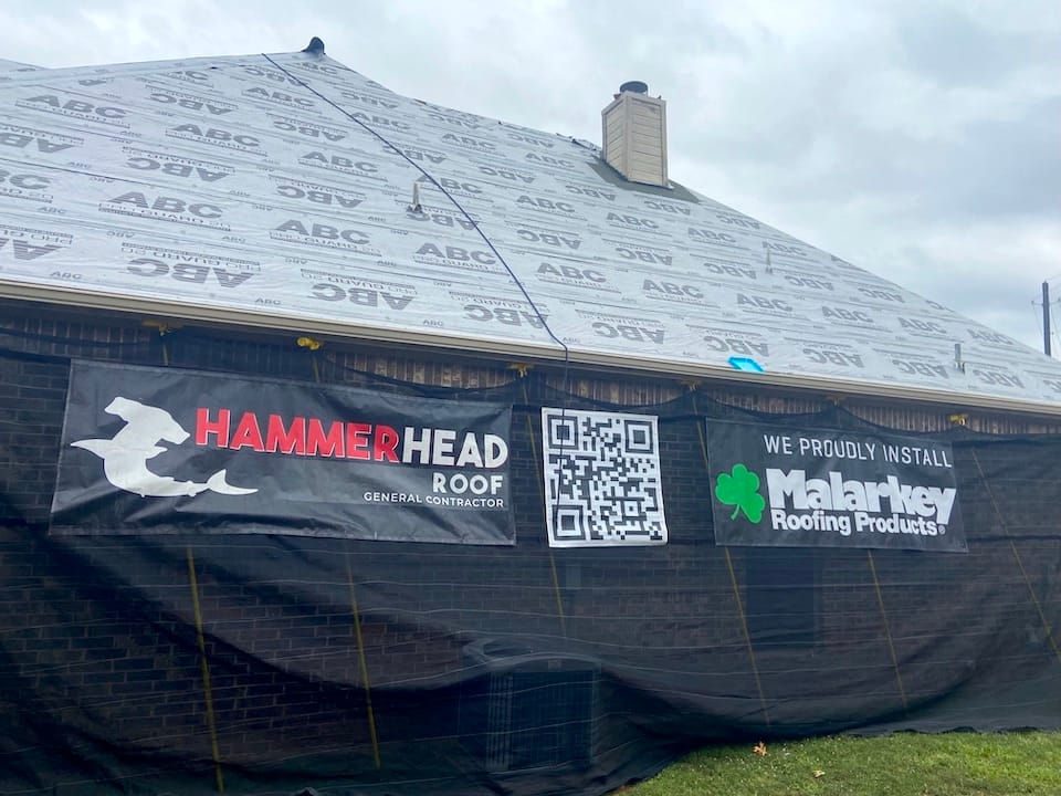 Hammerhead Roof signs on side of house in process of getting a new roof