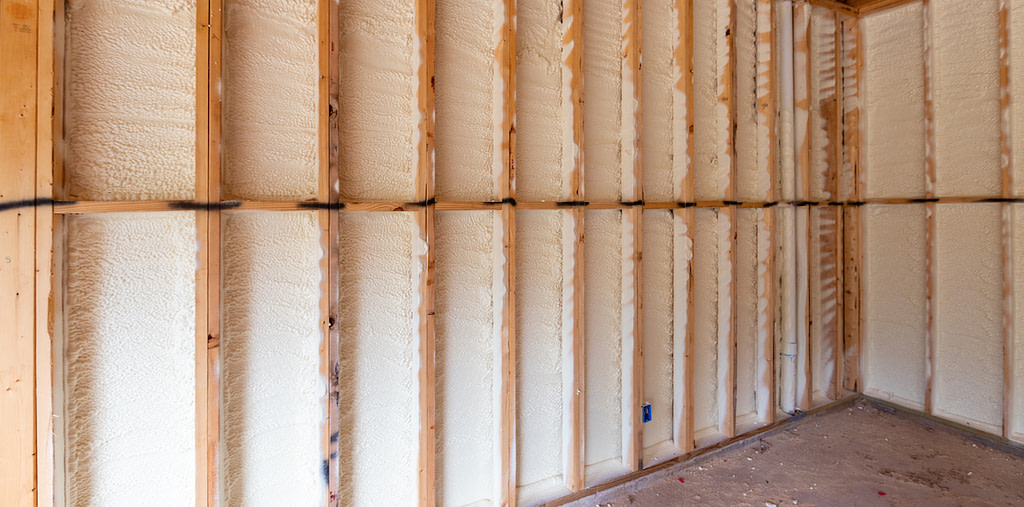 Man spraying insulation in construction site