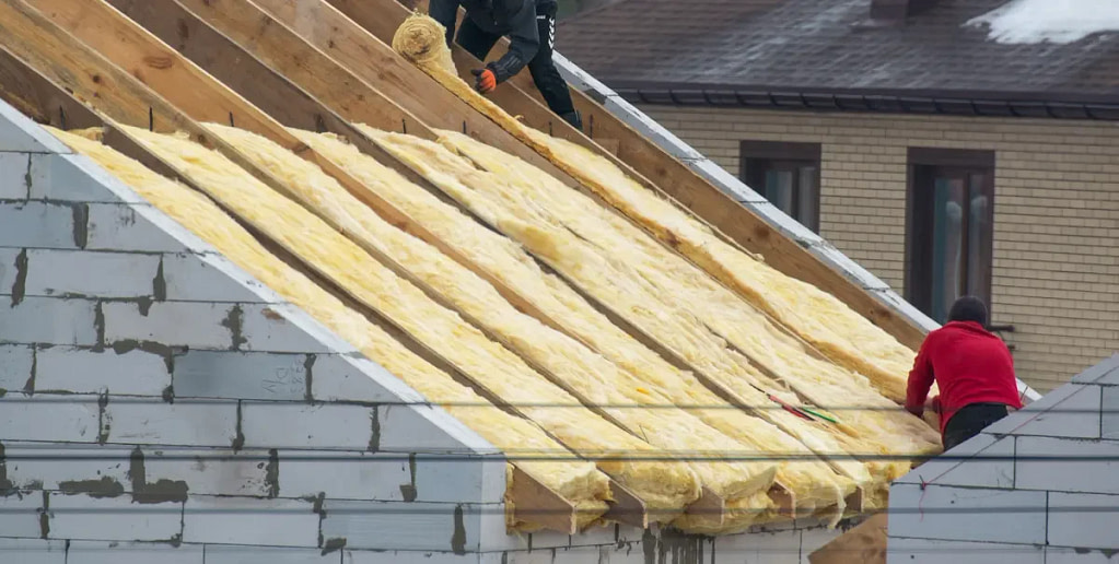 Workers installing insulation on roof