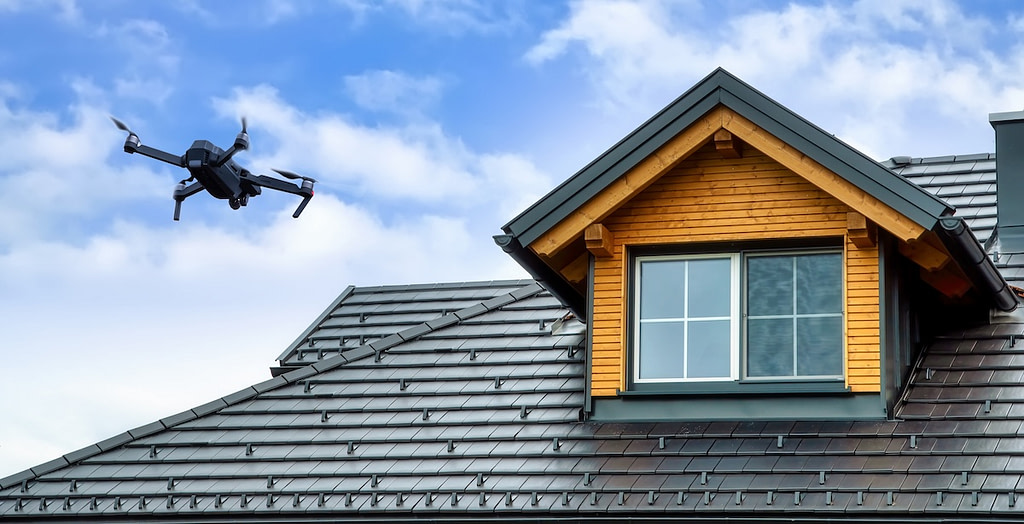 Drone in the air inspecting the roof over the house. Close-up of drone and roof.