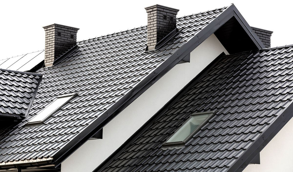 a white house with black metal tile roof