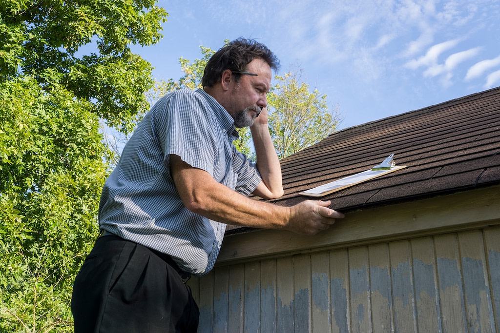 Insurance adjuster checking hail damage.