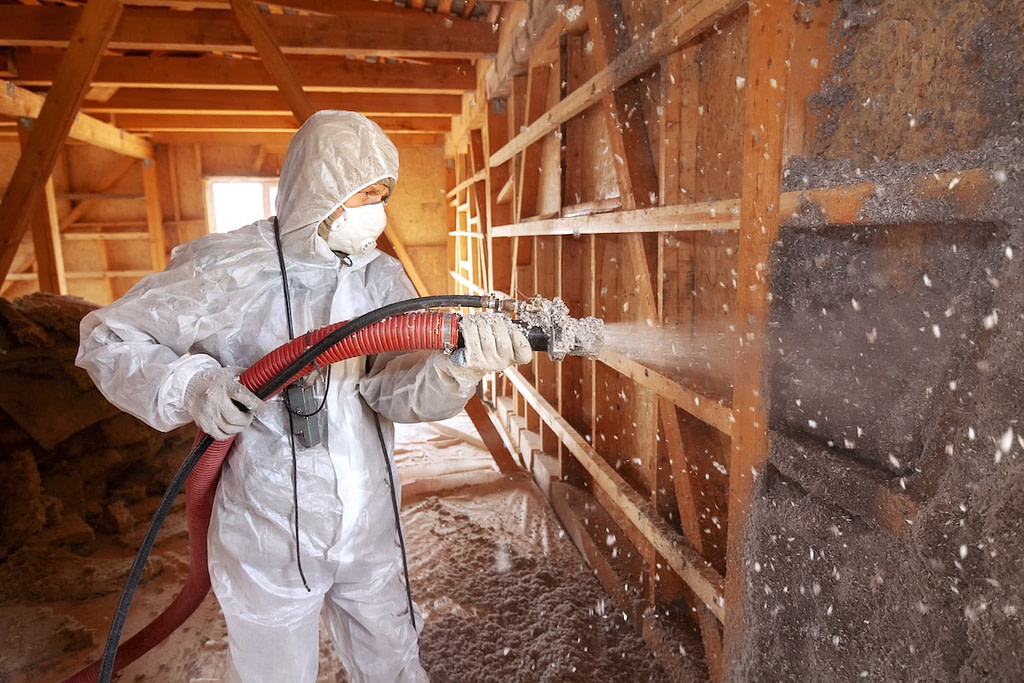 Spray insulation. Spraying cellulose insulation on the wall.