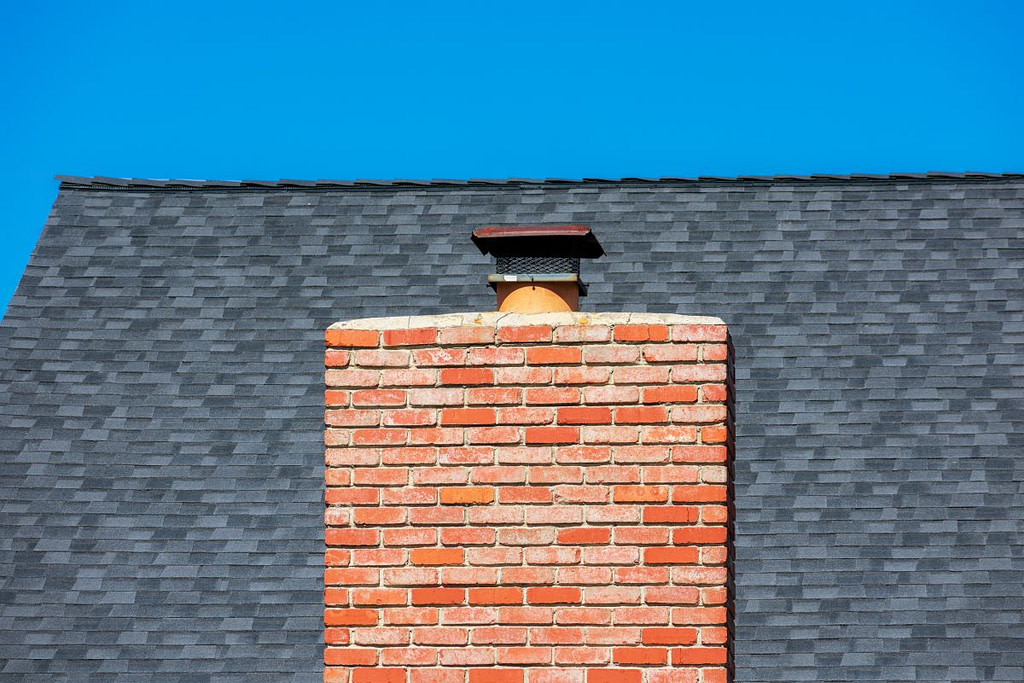 Wide red brick chimney with cap