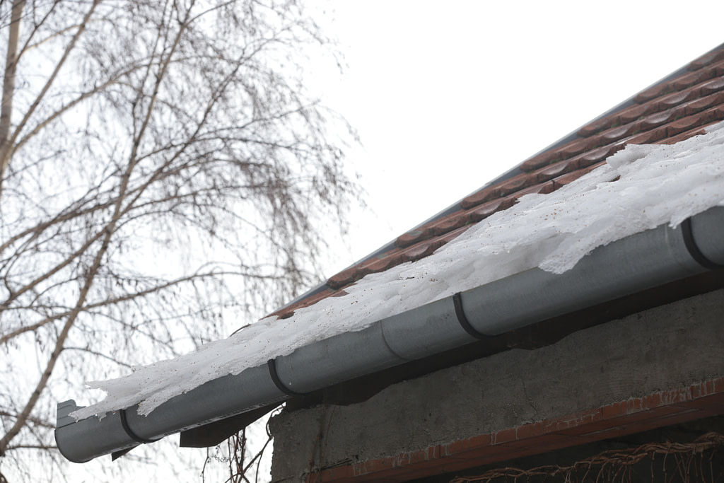 Dangerous Ice Dams on Roof and Gutter Causing Winter House Damage