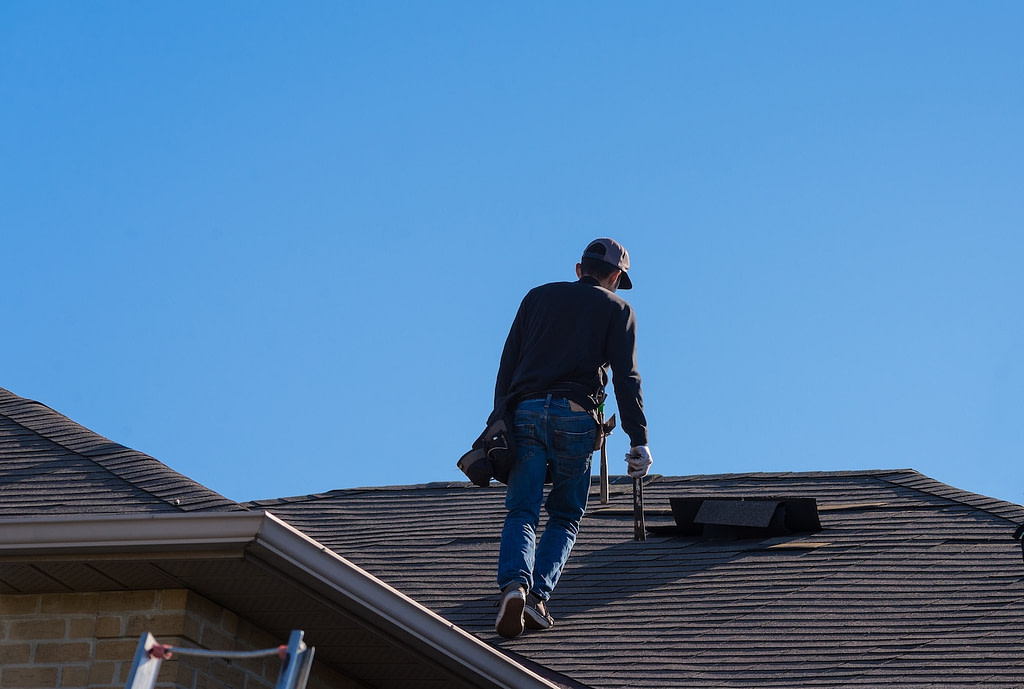 Worker walking on a damaged roof