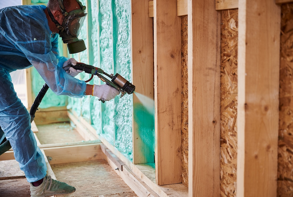 Man spraying insulation in construction site