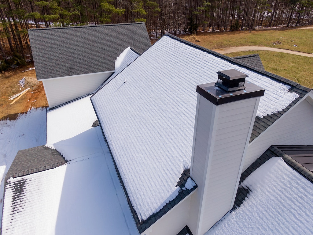 drone image of chimney cap with snow on roof