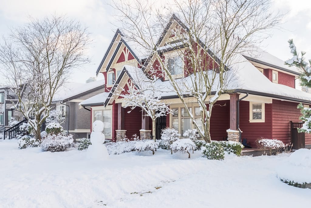Red house with insulated vinyl siding in snow storm