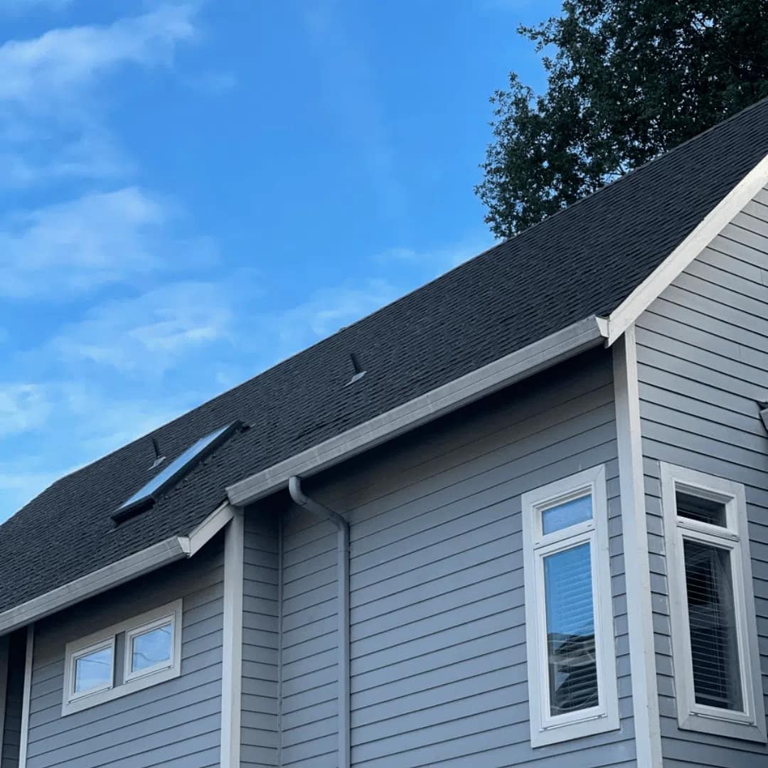 portland home with skylight on asphalt shingle roof and gray siding