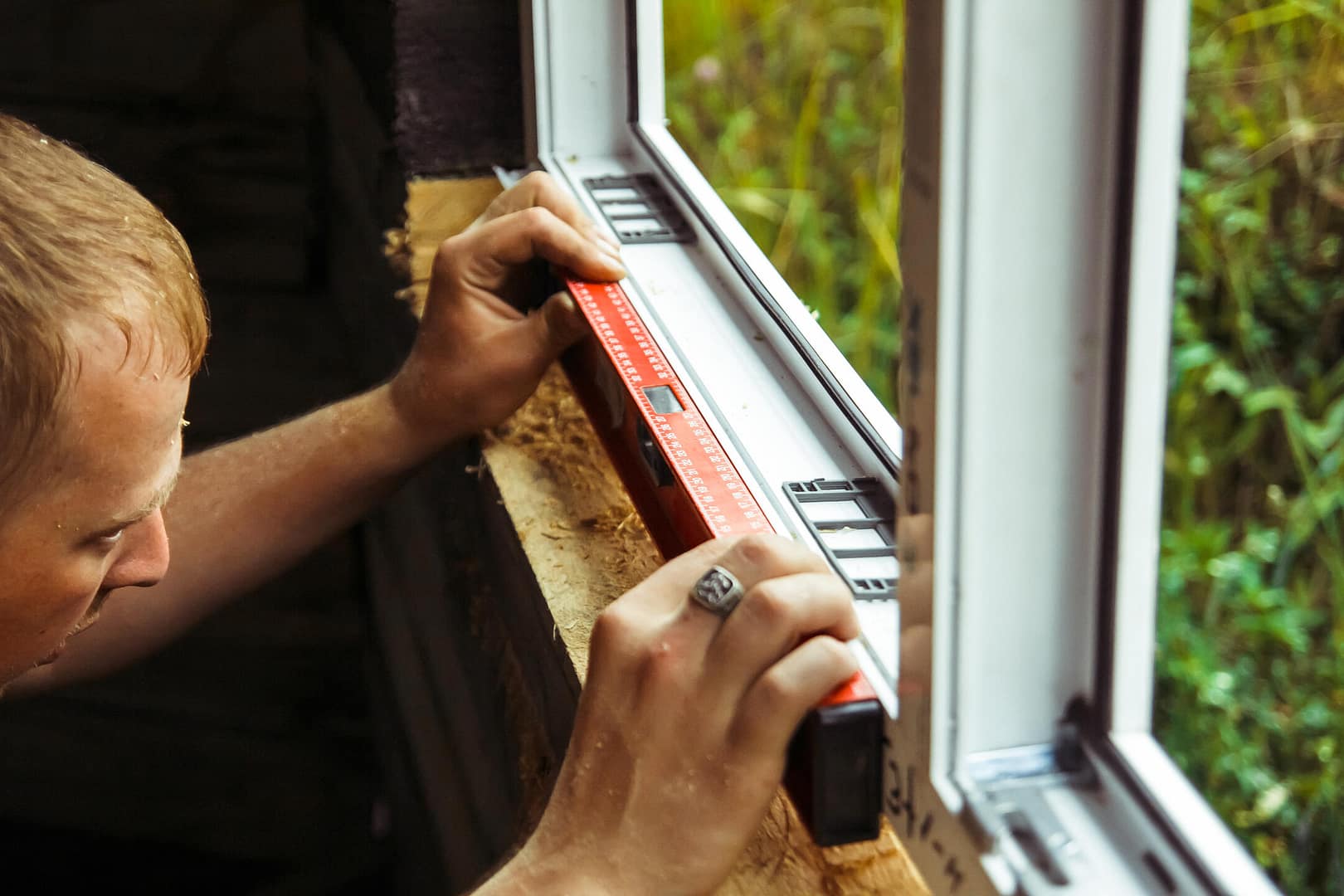 how to measure for replacement windows-man using a level to ensure new window is installed correctly