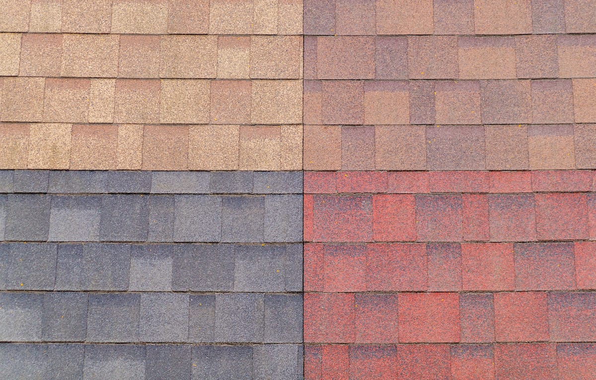 Close-up image of a roof by Houston Roofing showcasing four sections of different colored shingles: the top left is light brown, the top right is dark brown, the bottom left is dark gray, and the bottom right is red.