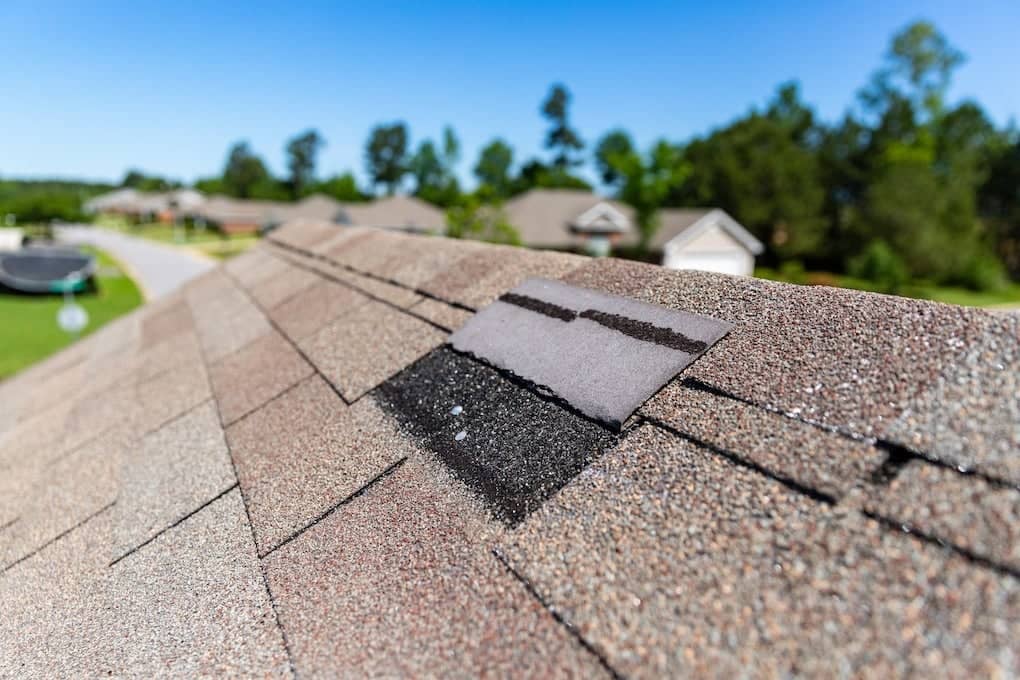 lifted shingles on roof due to signs of storm damage.