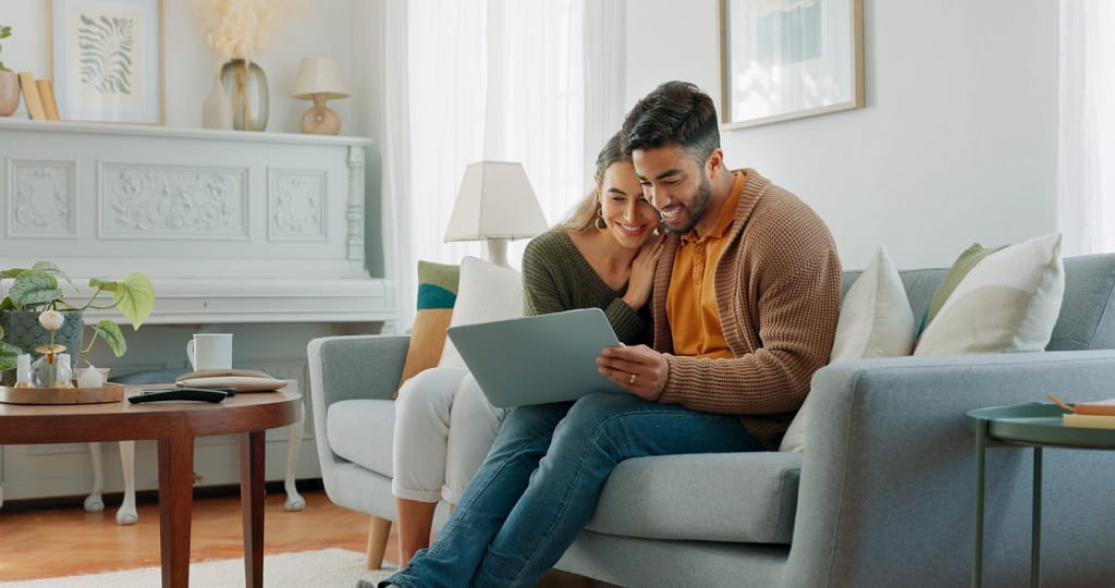 happy younger couple hang out on the couch in their rogers home