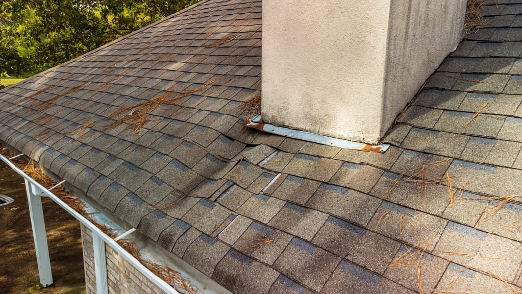 close up of asphalt shingle roofing system with extreme roof leaking and sagging