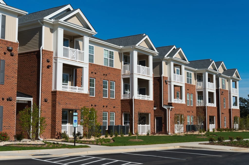 Tan and red condos overlooking a parking lot