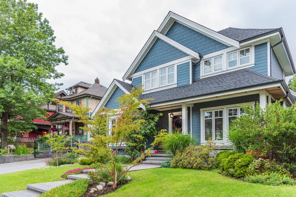 Blue Minnesota home with black gutters installed by Northface Construction