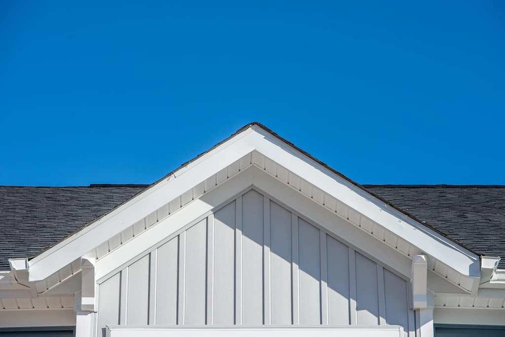 close up of gable roof with new vertical siding installation