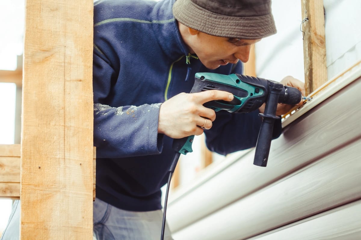 house vinyl siding installation by a worker