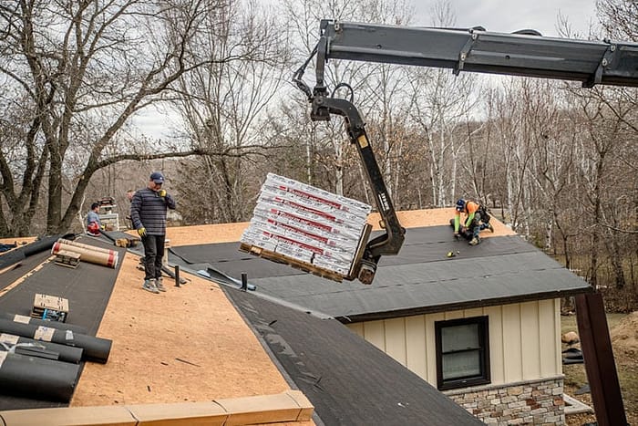 pallets of shingles being lifted by crane