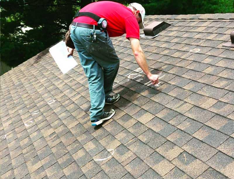 roofer marking roof damage by northface construction
