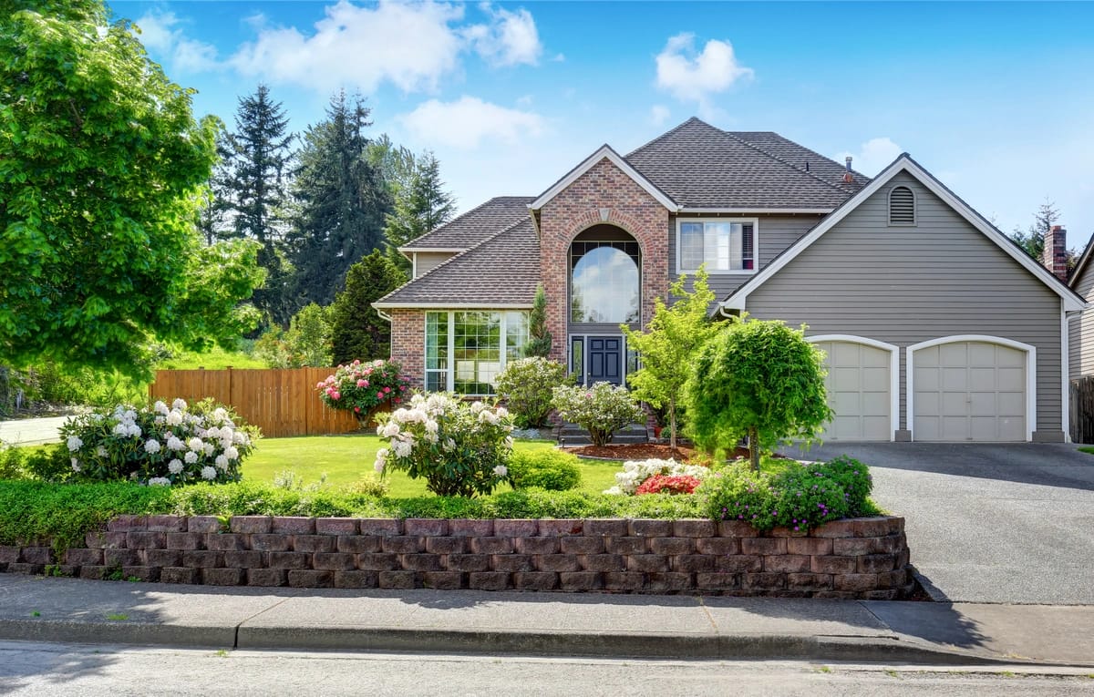 house with double garage door and garden