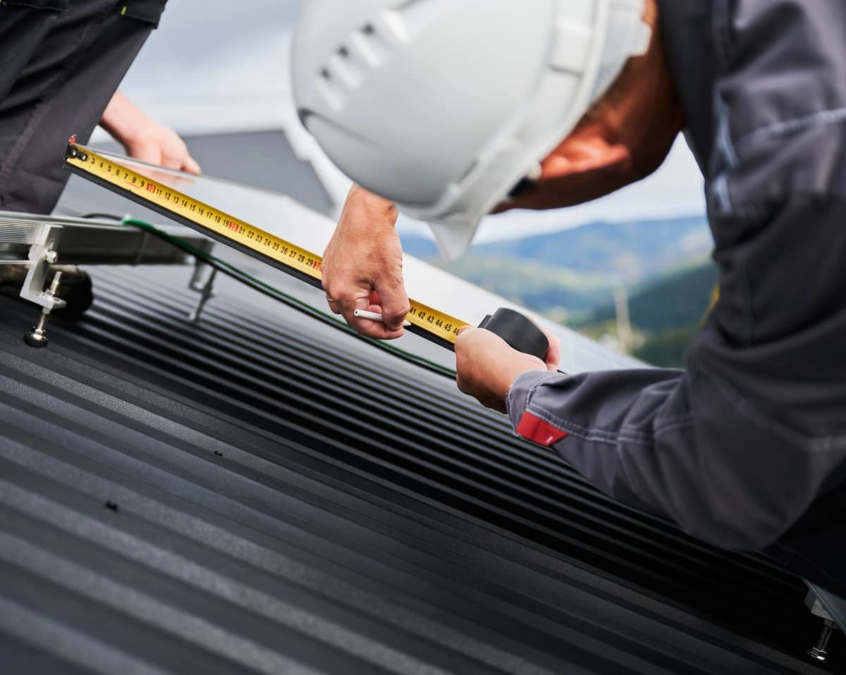 worker measuring the metal roof