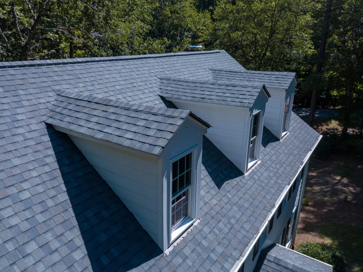 side view of asphalt roof replacement installed by shingle and metal roofing